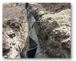 Tubería negra instalada en zanja excavada tierra