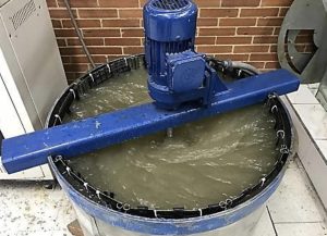 Figura 1. Montaje para ensayo de abrasión. Tanque azul industrial con motor y agua turbia