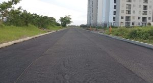 Calle asfaltada recién pavimentada junto a edificio residencial