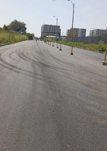 Carretera nueva con marcas de construcción y bloques residenciales
