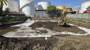 Obra de construcción con excavadora y tanques industriales