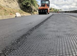 Rodillo compactador asfáltico naranja en obra de carretera