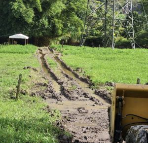 Surcos erosionados en terreno agrícola rural con equipamiento industrial