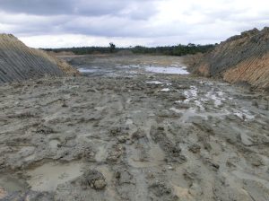 Cantera inundada con paredes de tierra y agua estancada