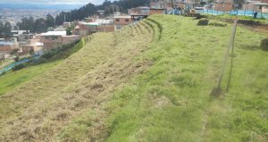 Terreno agrícola en ladera andina con asentamiento urbano