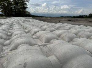 Sacos blancos de arena apilados en playa tropical